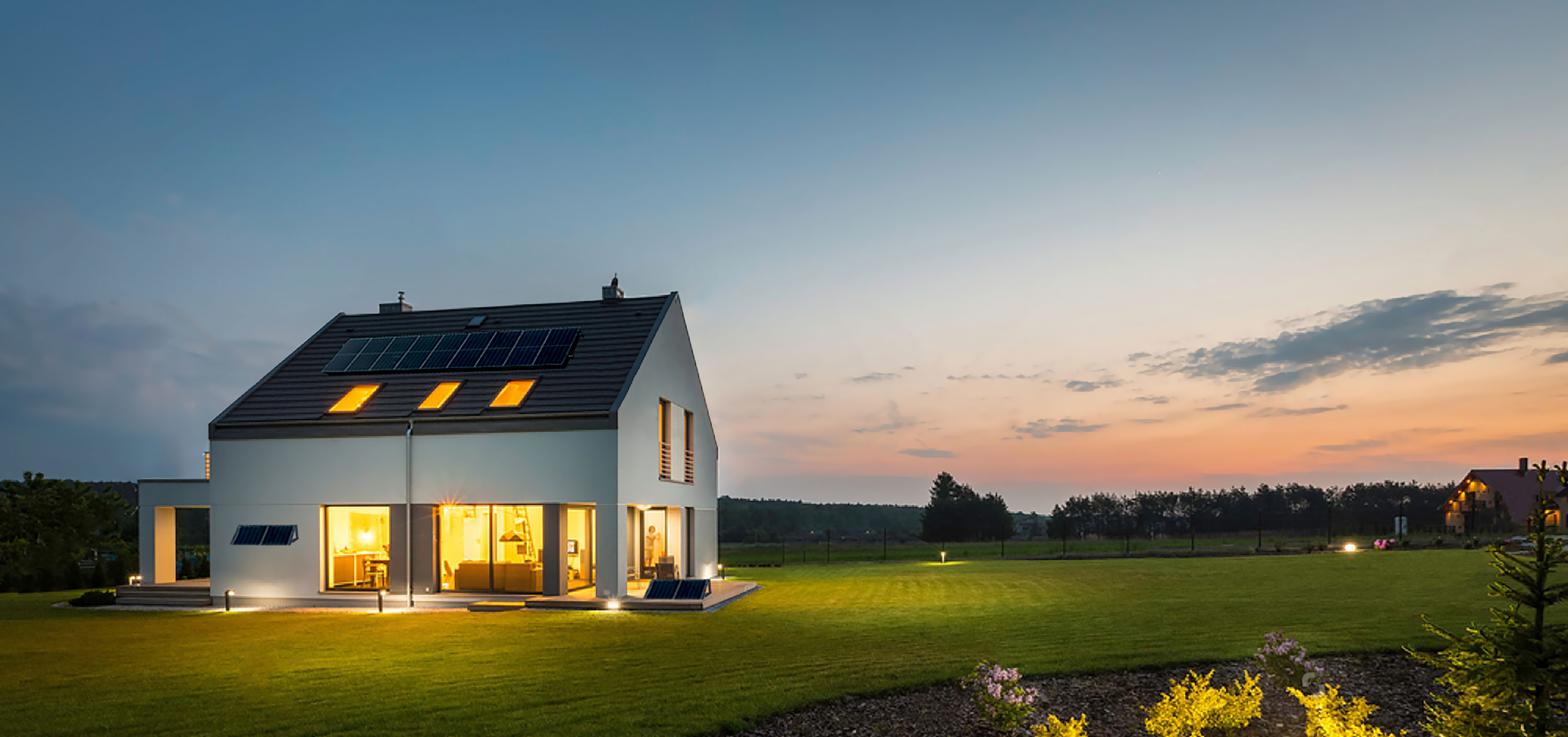 Visuel d'une maison équipée de panneaux solaires en toiture et d'un kits solaires plug & play sur la terrasse